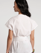 Woman wearing a white dress with a plain background