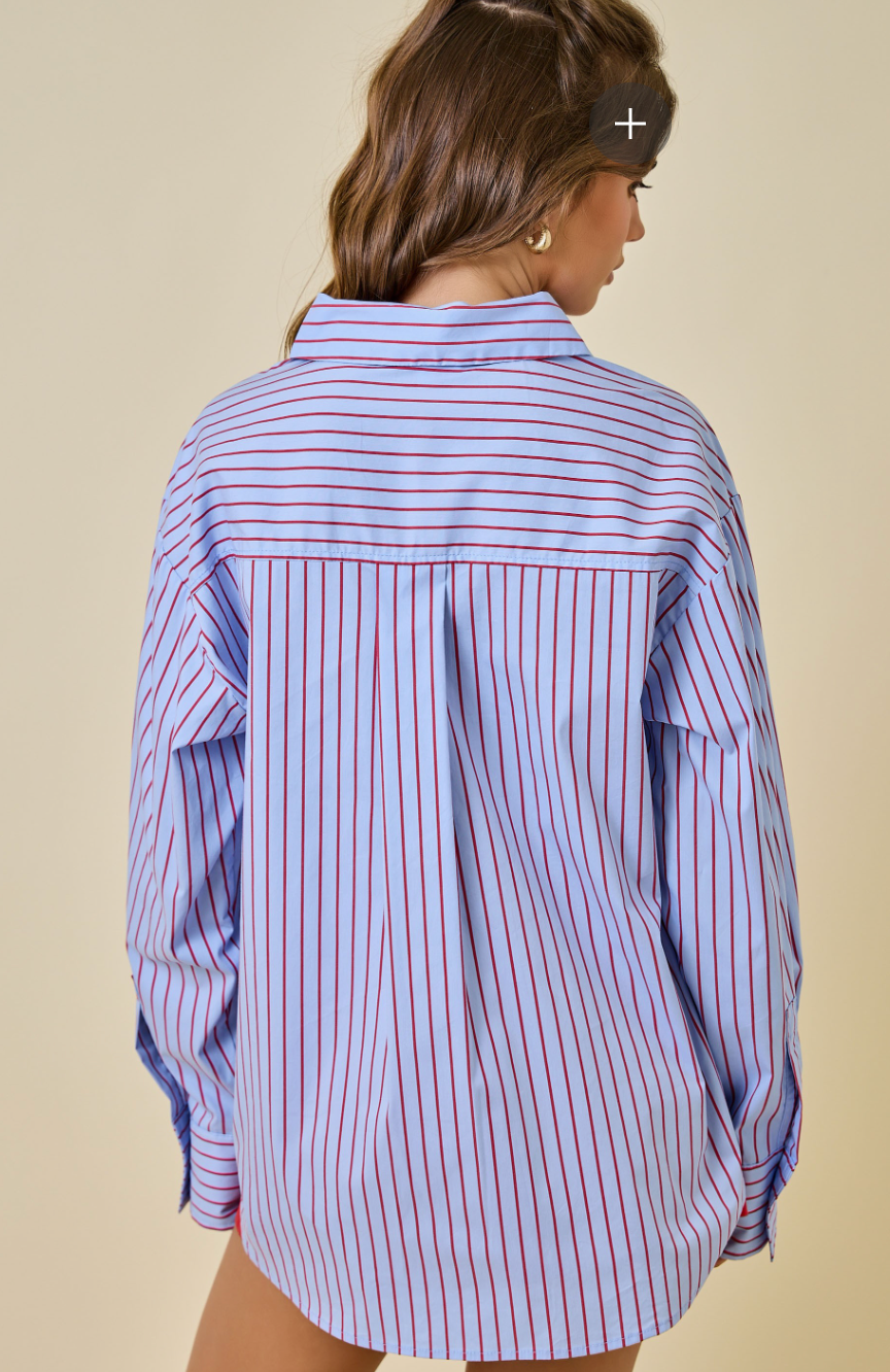 Woman wearing a blue and white striped shirt against a beige background