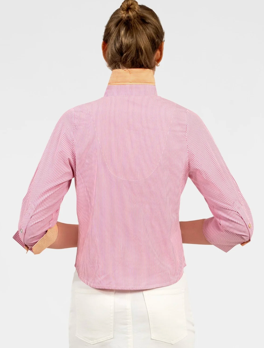 Person wearing a pink and white striped shirt with rolled-up sleeves on a light gray background