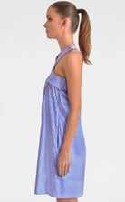 Woman wearing a blue and white striped dress on a plain background
