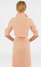 Woman wearing a beige ribbed dress with a white background