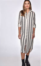 Woman wearing a black and white patterned dress on a white background