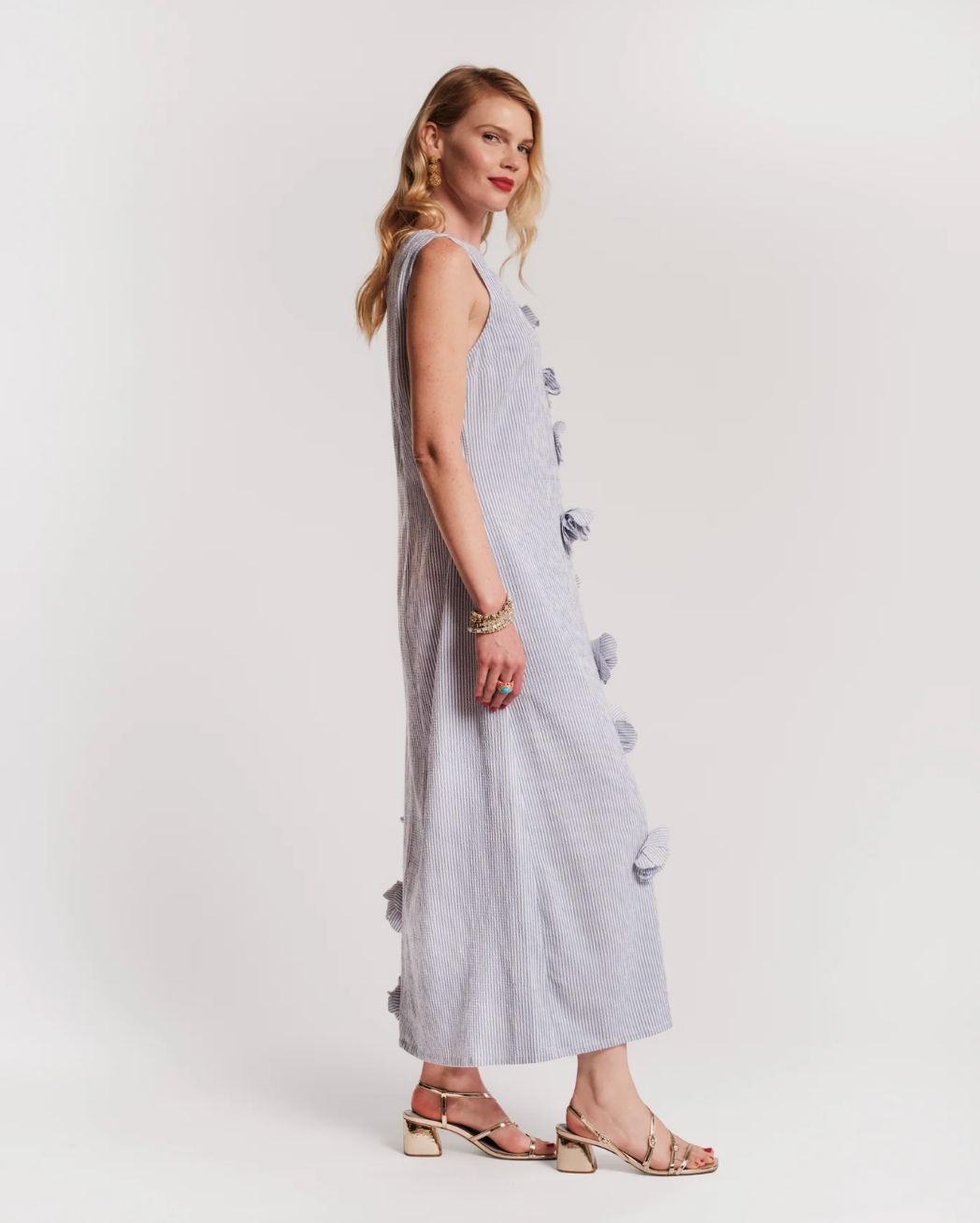 Woman wearing a light blue dress with button details on a white background