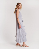 Woman wearing a light blue dress with button details on a white background