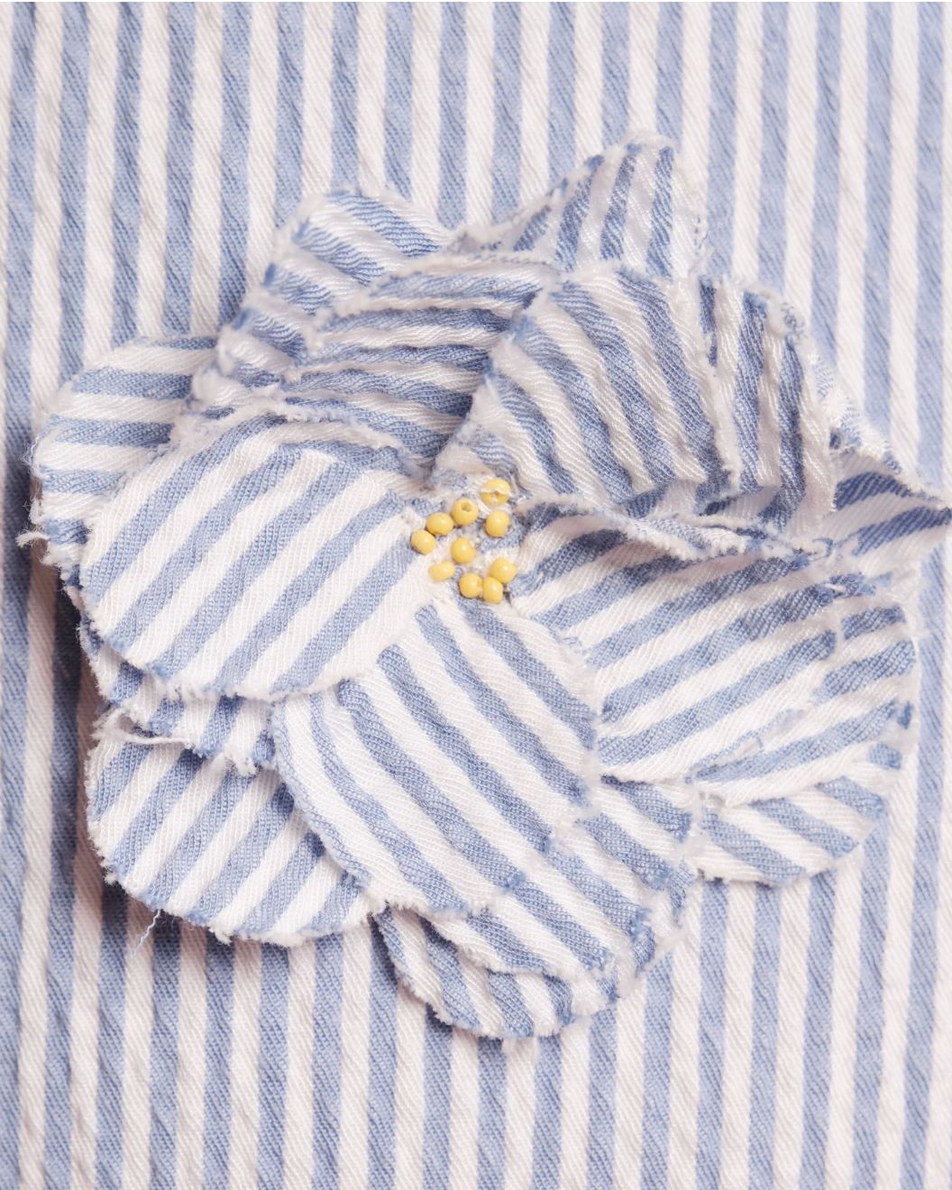 Blue and white striped fabric with ruffled edges on a matching background