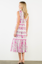 Woman wearing a floral dress with pink and purple patterns on a white background