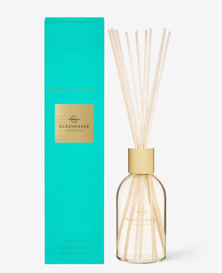 Glasshouse diffuser bottle with reeds and packaging on a white background