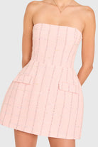 Pink strapless dress worn by a person on a light gray background