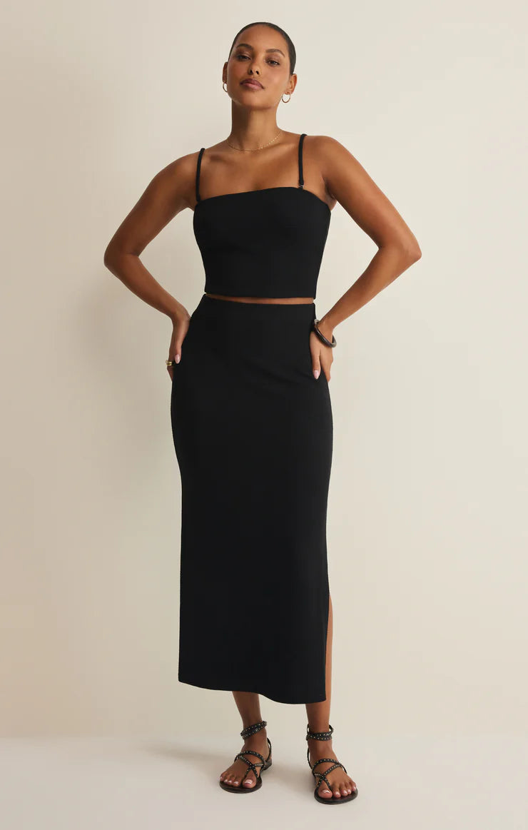 Woman wearing a black two-piece outfit on a beige background