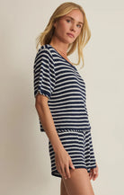 Woman wearing a navy and white striped dress against a plain background