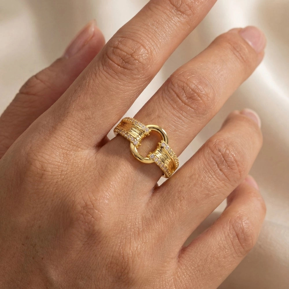 Gold ring on a person's finger with a blurred background