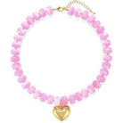 A pink beaded necklace with a gold heart pendant and gold chain clasp, displayed on a clean white background.