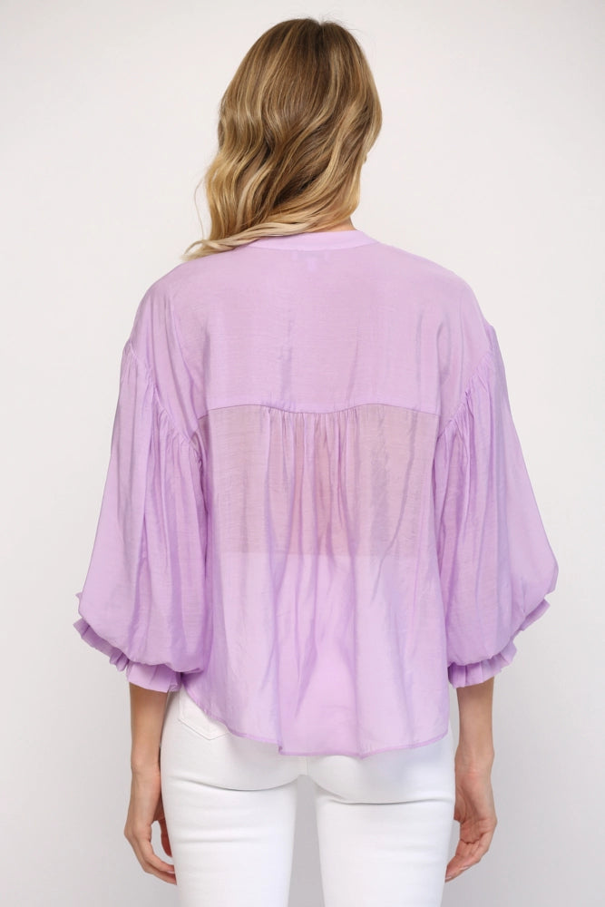 Person wearing a light purple blouse with a white background