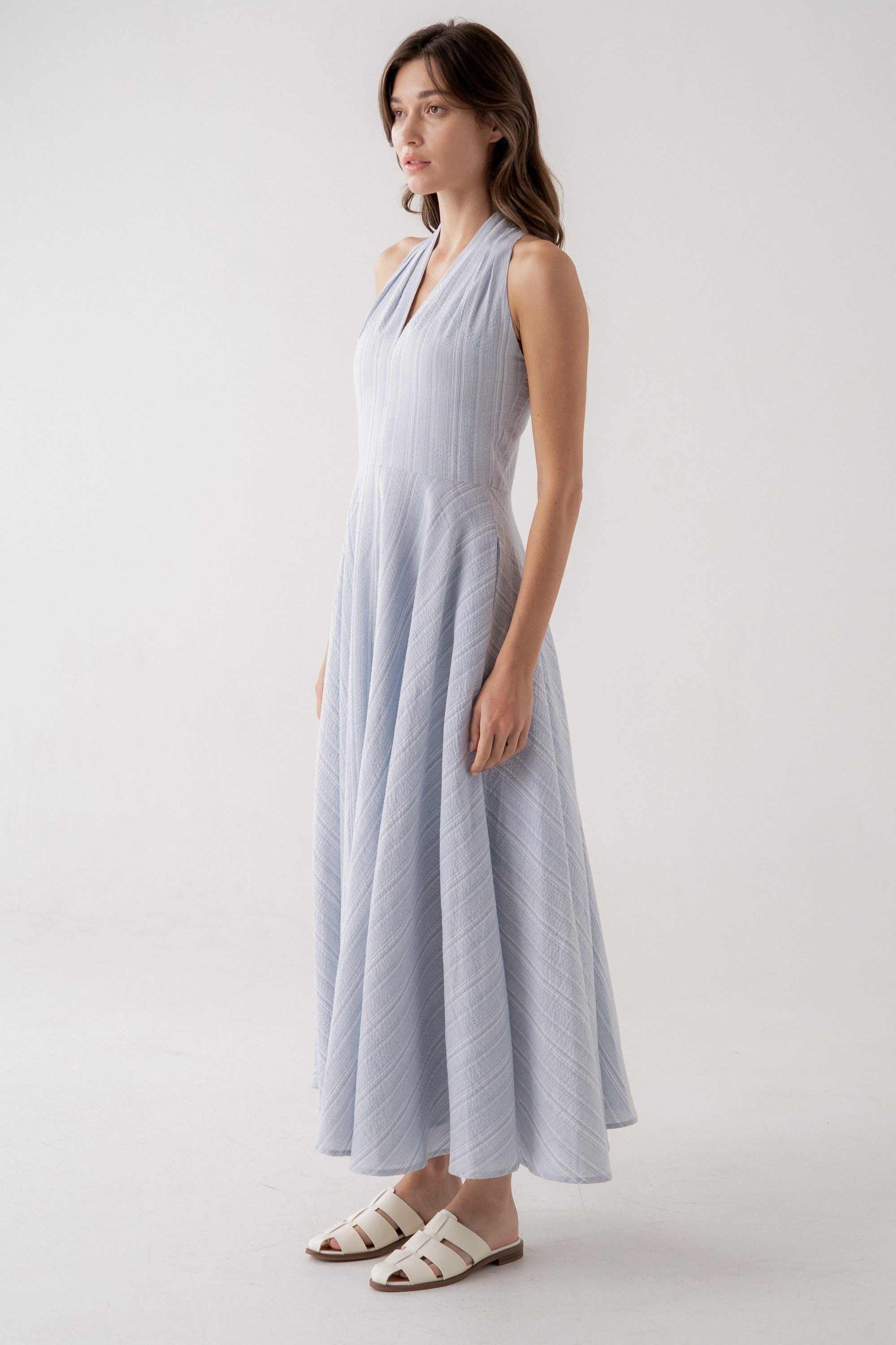 Woman wearing a light blue dress on a white background