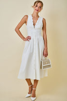 Woman wearing a white dress with a beige background