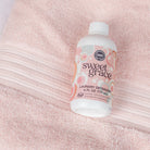 Bottle of Sweet Grace laundry detergent on a pink towel