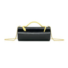 A black leather cylindrical handbag with a gold top handle and gold chain strap, shown against a plain white background.