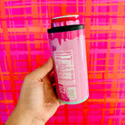 Hand holding a pink supplement container with a colorful plaid background