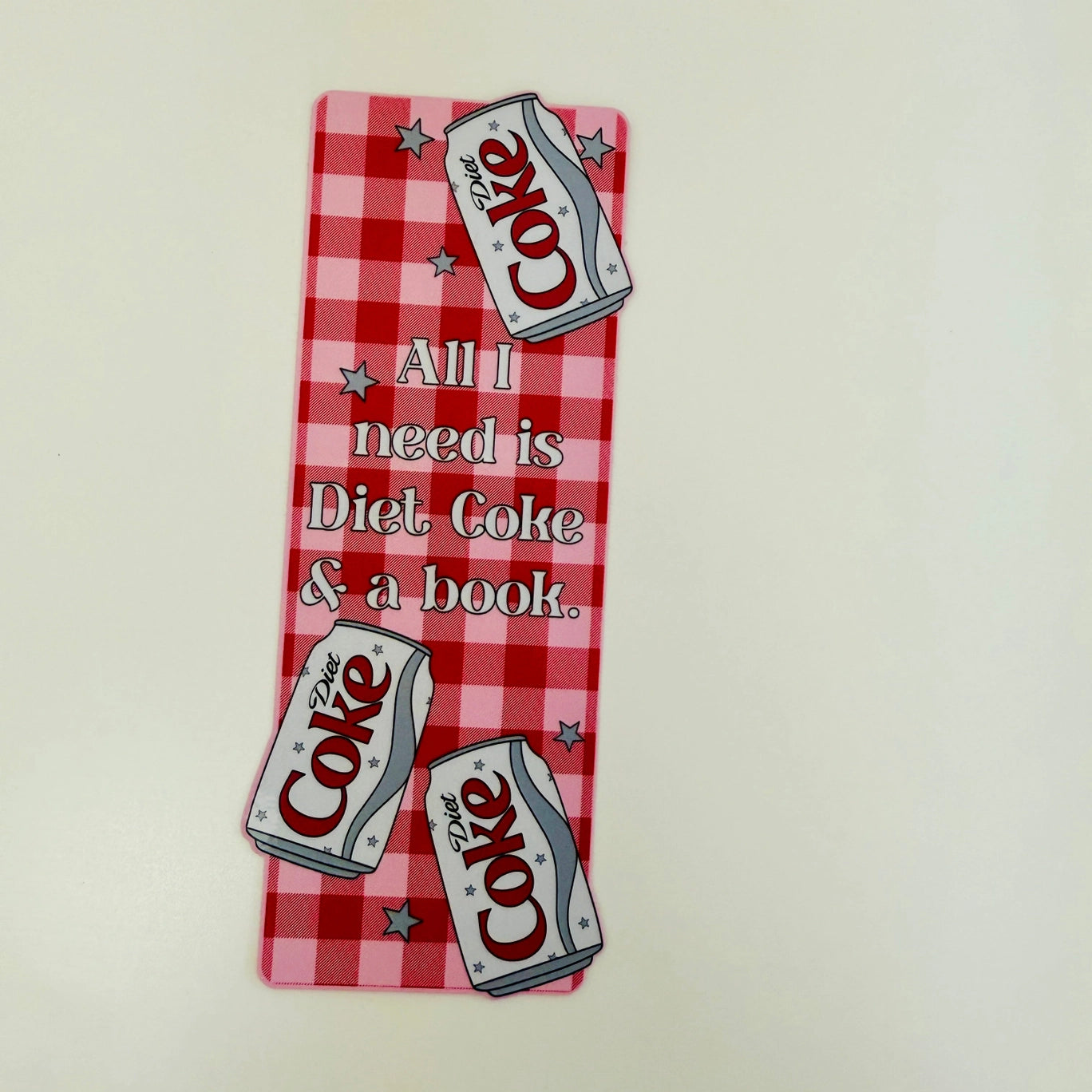 Decorative sign with Diet Coke cans and text on a red and white checkered background