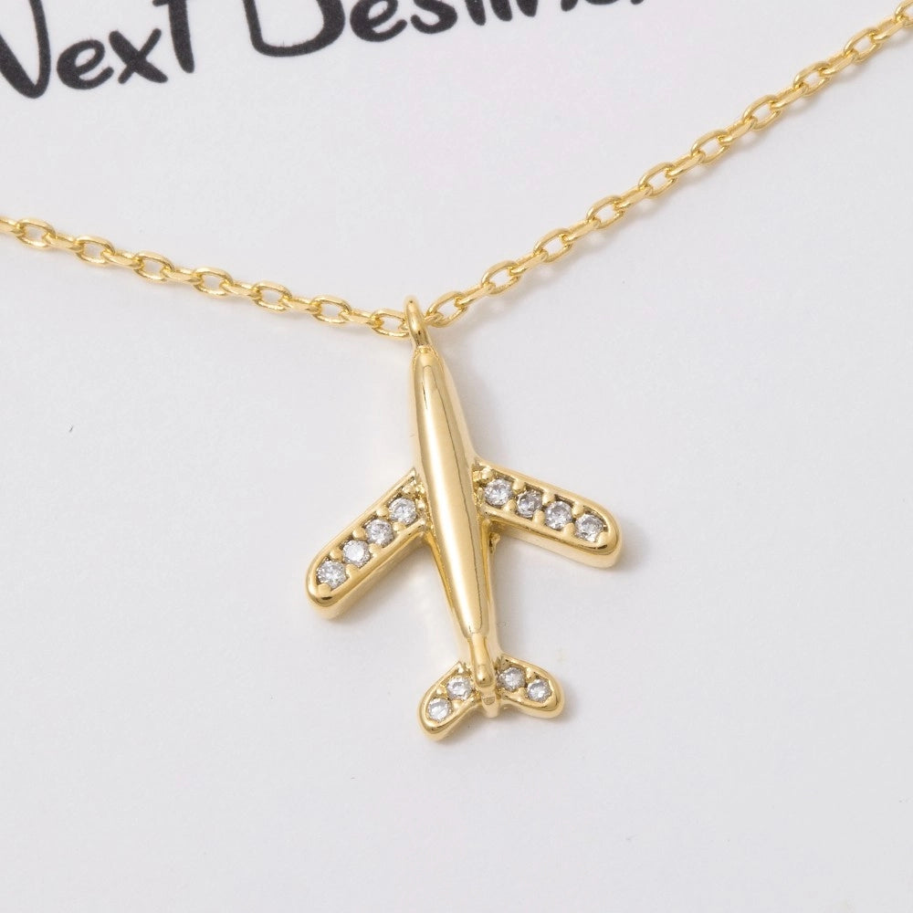 Gold airplane necklace with rhinestones on a white background