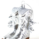 Silver cowboy boot ornament with tinsel on a white background
