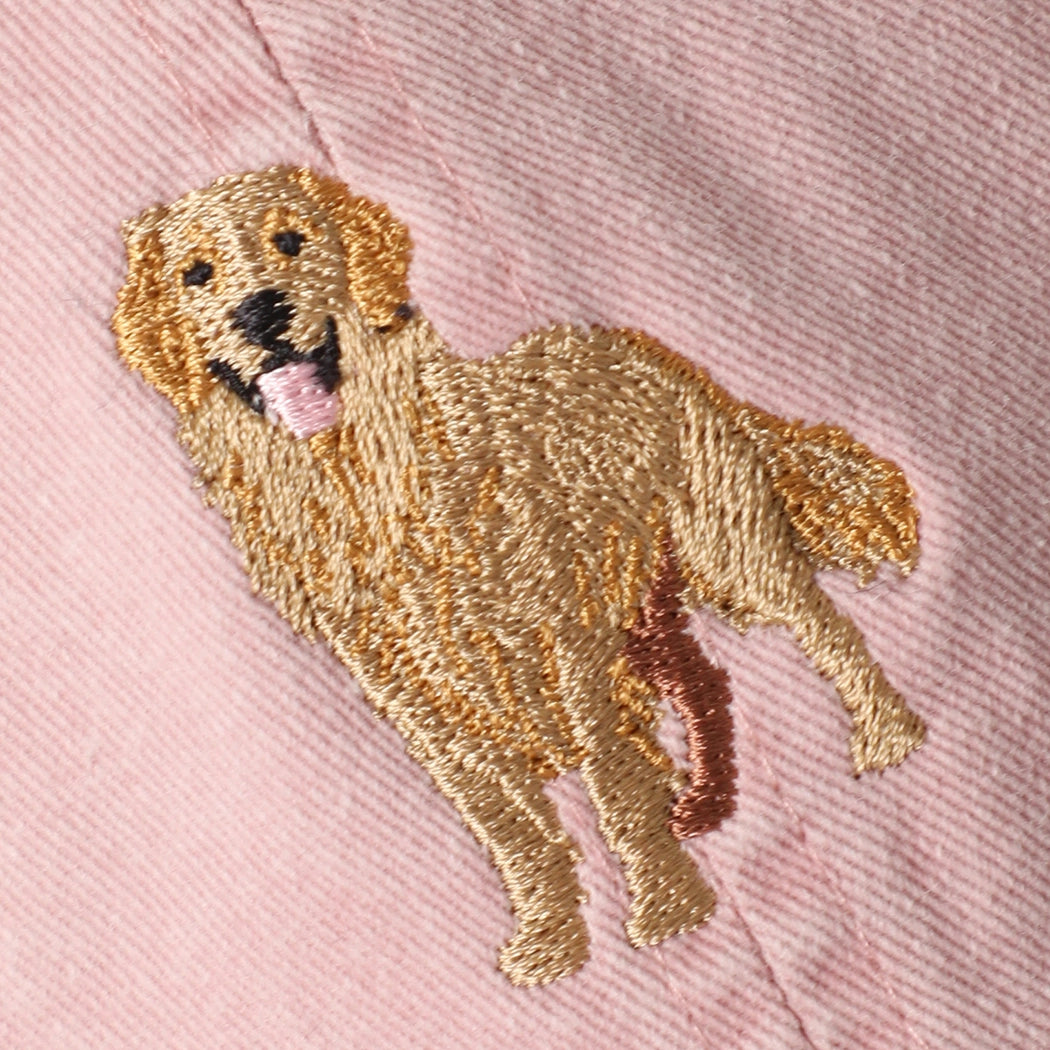 Embroidered golden retriever patch on a pink fabric background