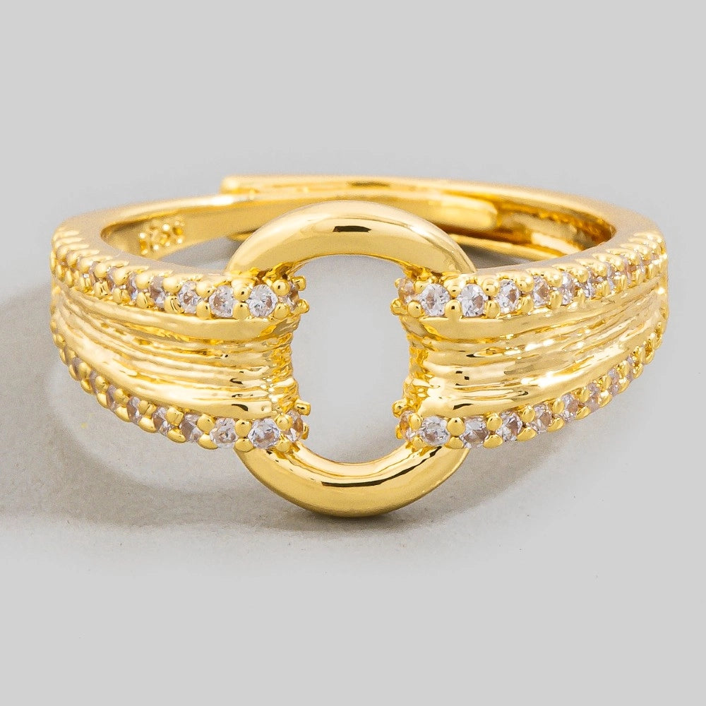 Gold ring with diamond accents on a light gray background