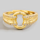 Gold ring with diamond accents on a light gray background