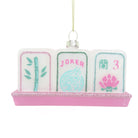 A decorative hanging ornament shaped like three Mahjong-style tiles on a pink glitter base, with a gold hanging string and a small clear rhinestone cap. The left tile shows green bamboo, the center tile says JOKER in pink with a light blue dragon motif, and the right tile shows a pink lotus and the number 3.