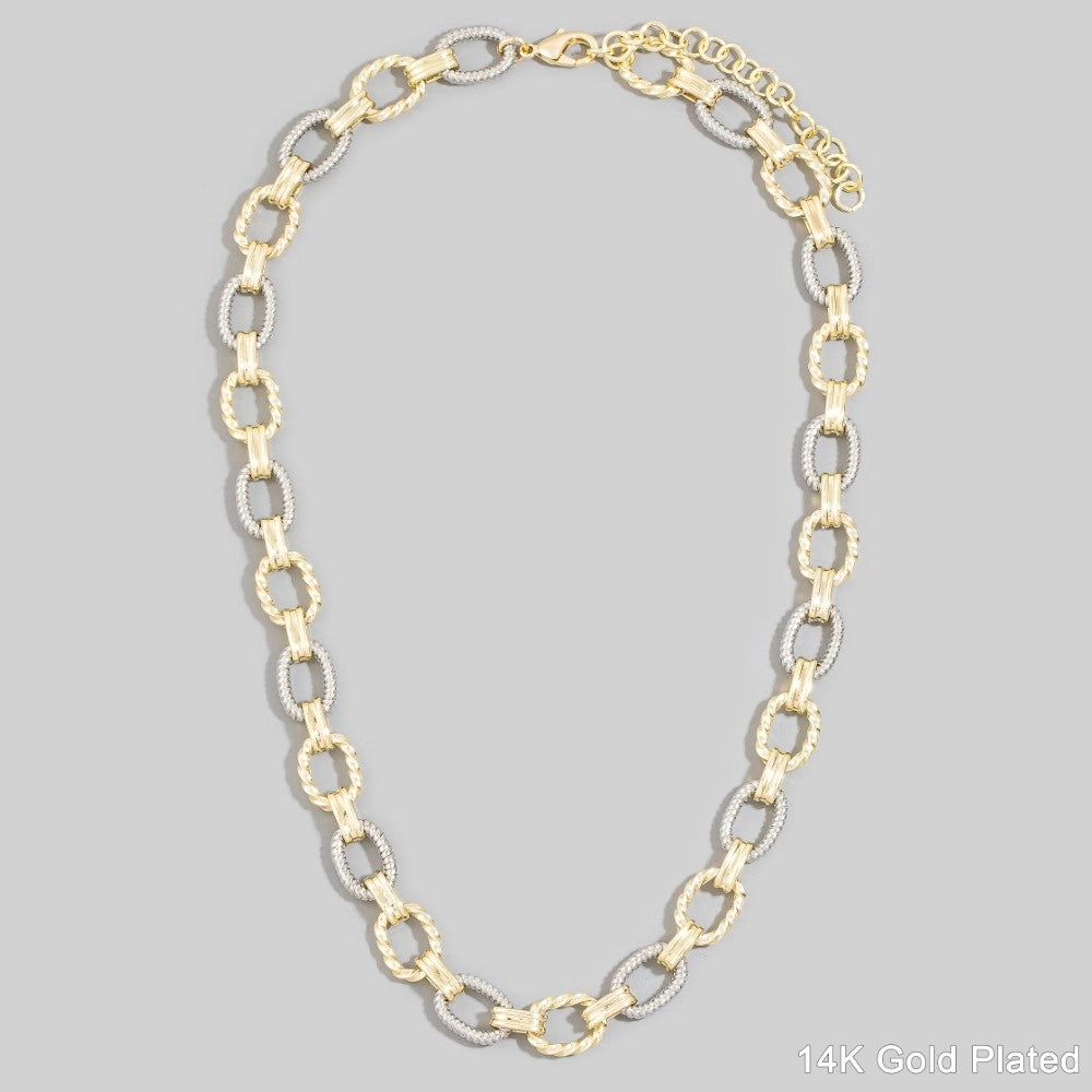 Gold chain necklace on a gray background