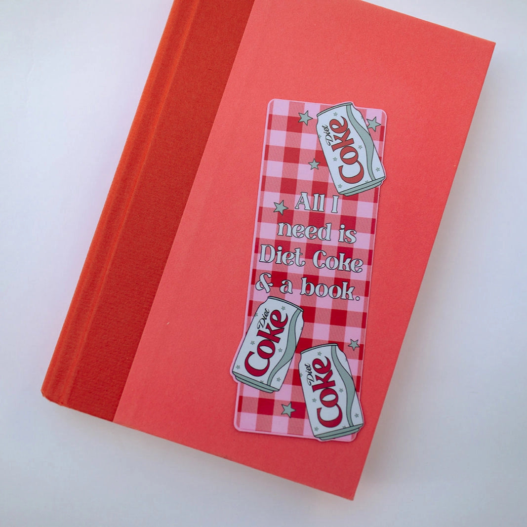 Red notebook with Diet Coke-themed bookmarks on a white background