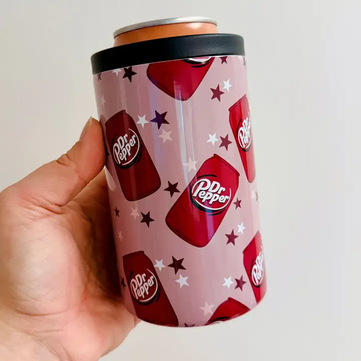Dr Pepper can with pink pattern and star detail held by a hand against a white background