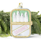 Decorative ornament shaped like a can of sardines with green background and gold glitter.