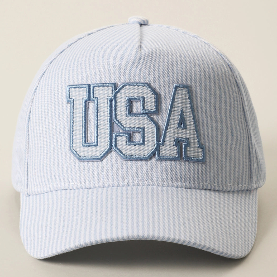 Light blue cap with 'USA' embroidery on a beige background