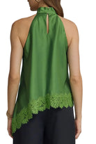 Green halter top with lace detail worn by a person on a gray background