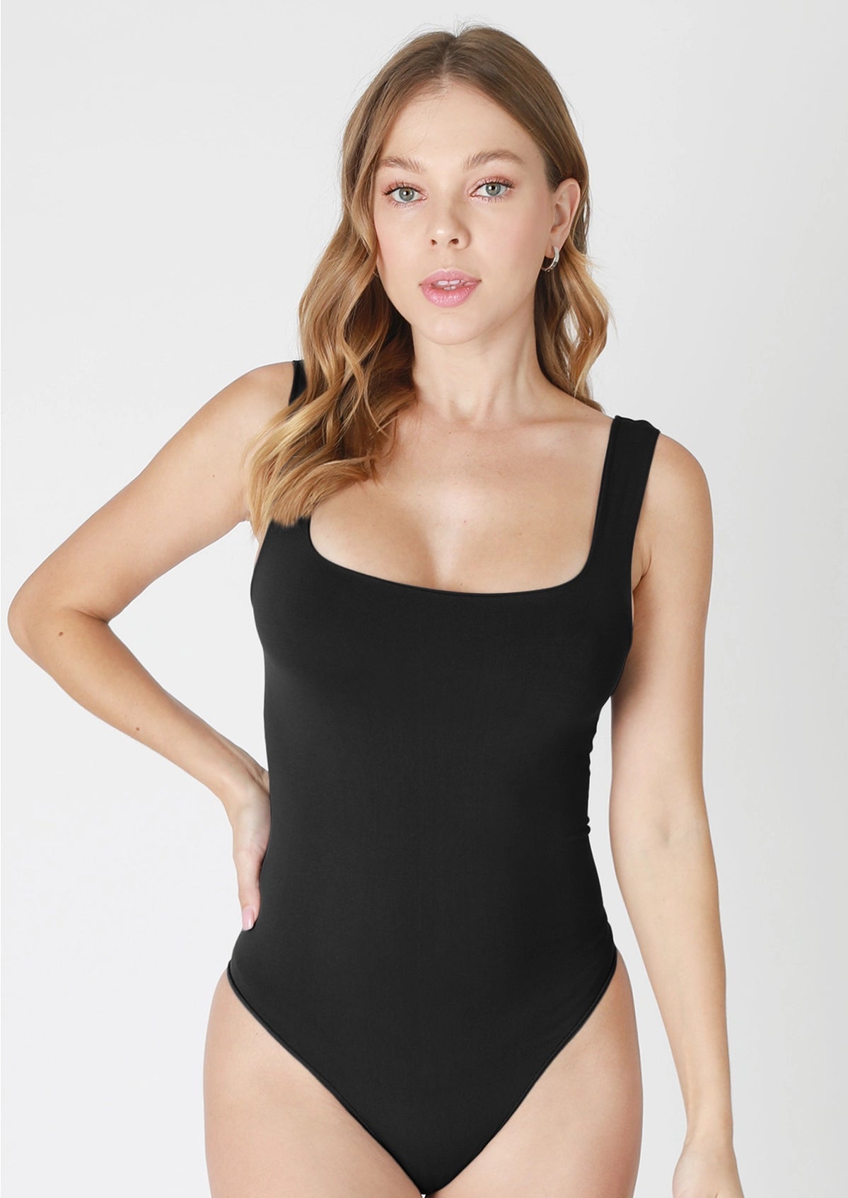 Woman wearing a black swimsuit against a white background