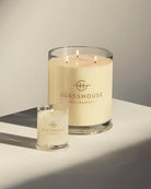 Two glass candles with 'Glasshouse Fragrances' logo on a neutral background
