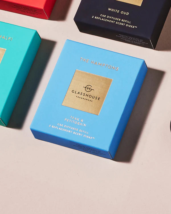 Blue packaging of Glasshouse Fragrances on a light surface