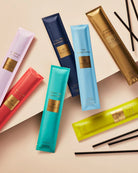 Colorful skincare product tubes with visible brand name on a beige background