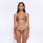 Woman wearing a leopard print bikini on a white background