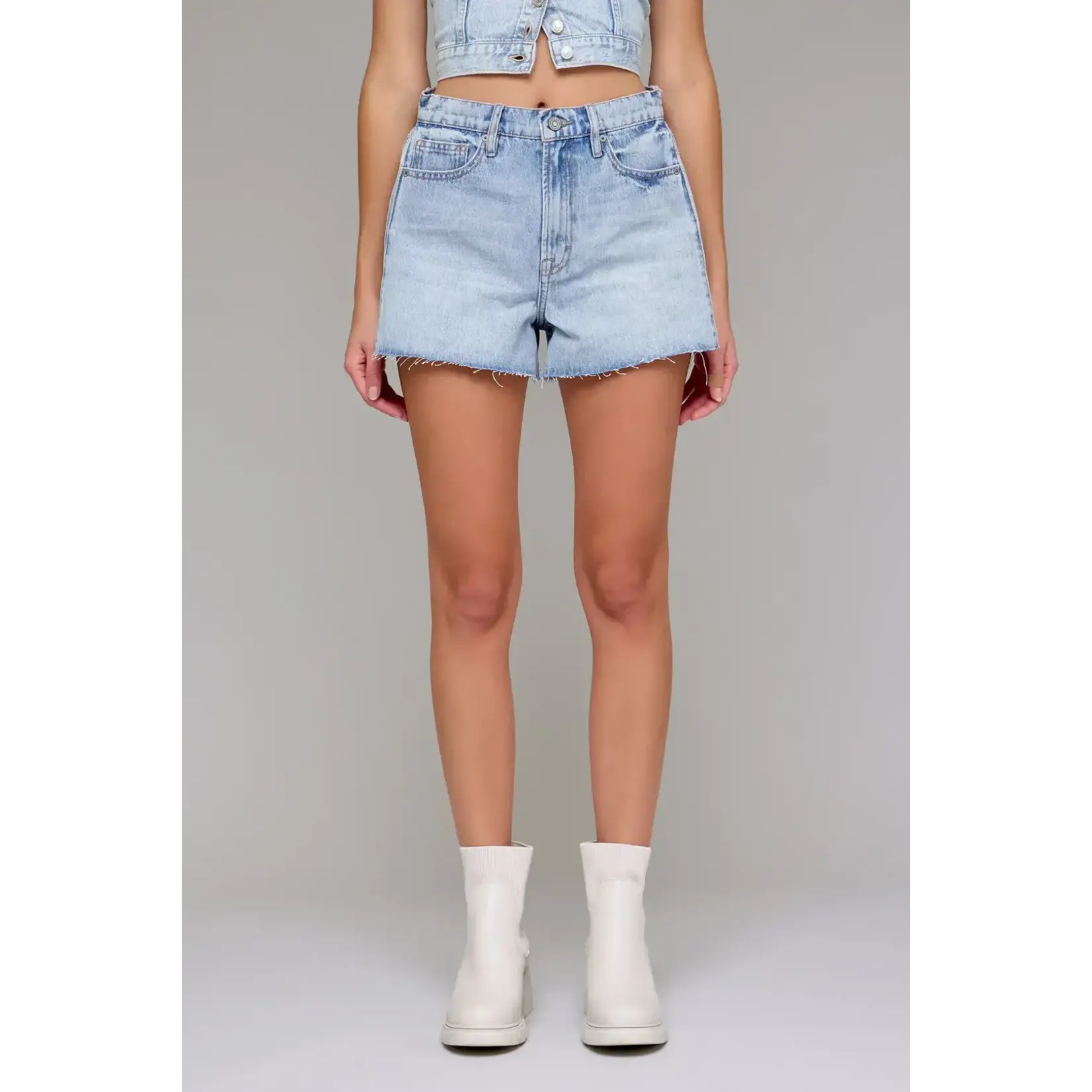 Person wearing light blue denim shorts on a gray background