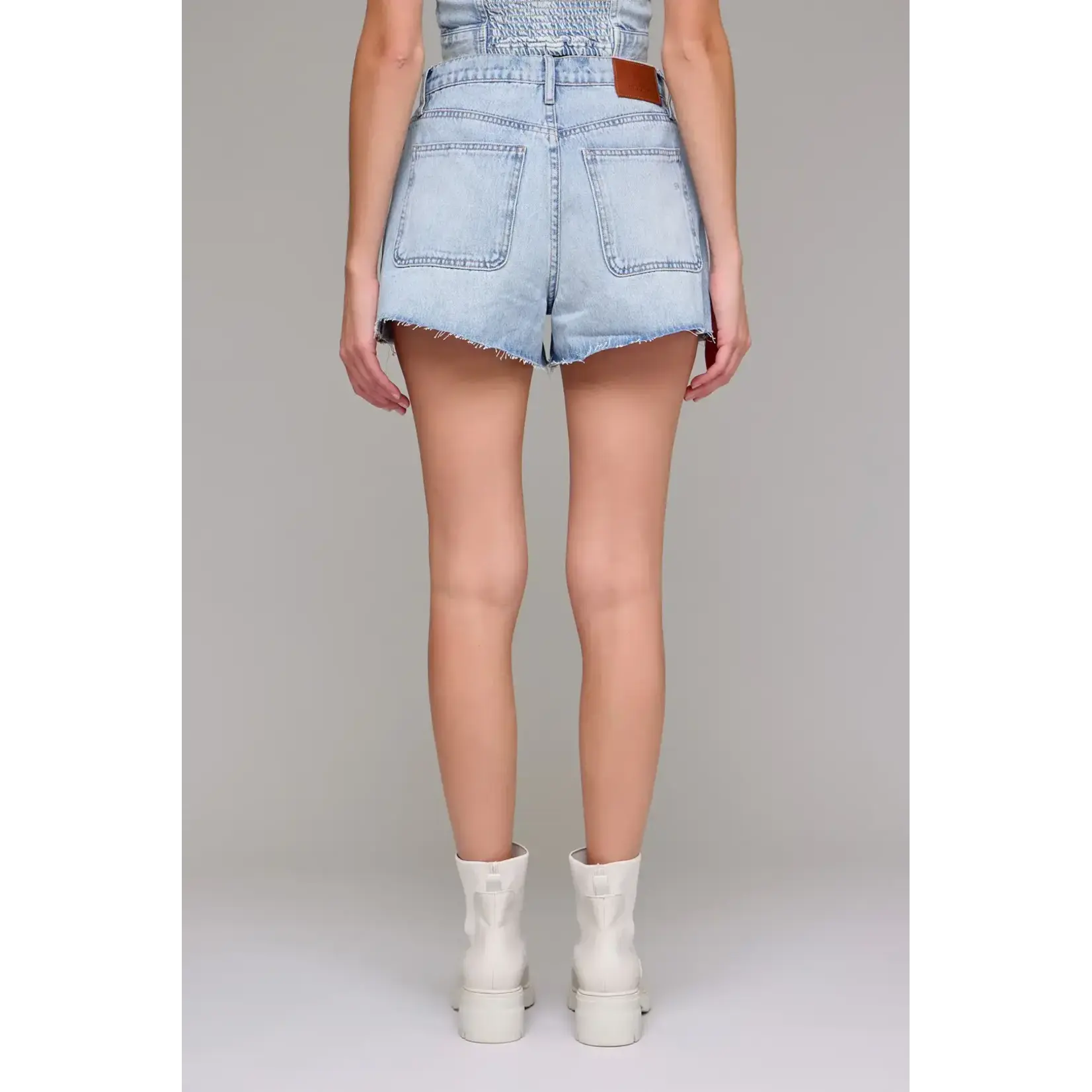 Light blue denim shorts worn by a person on a plain background