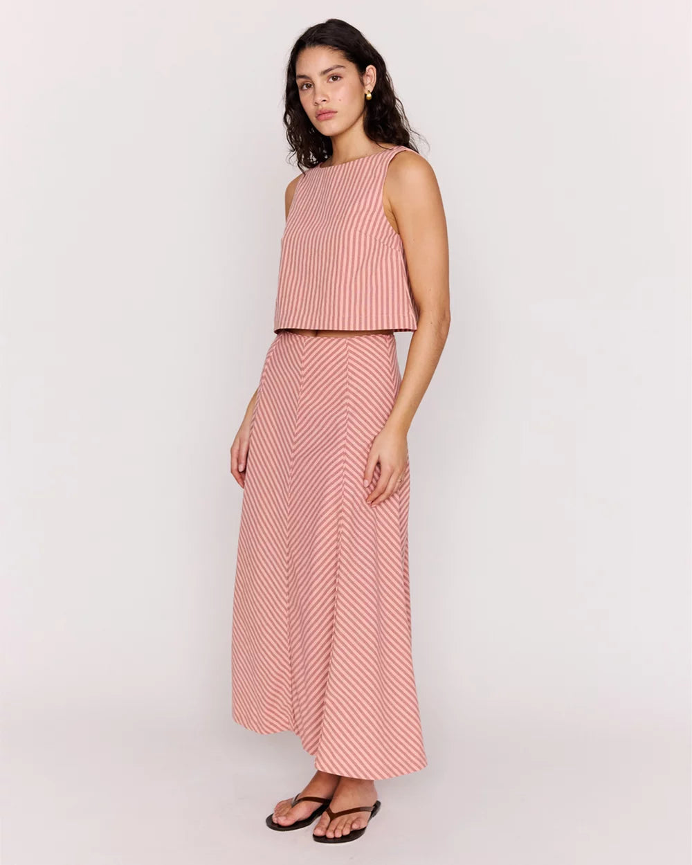 Woman wearing a pink striped outfit on a white background