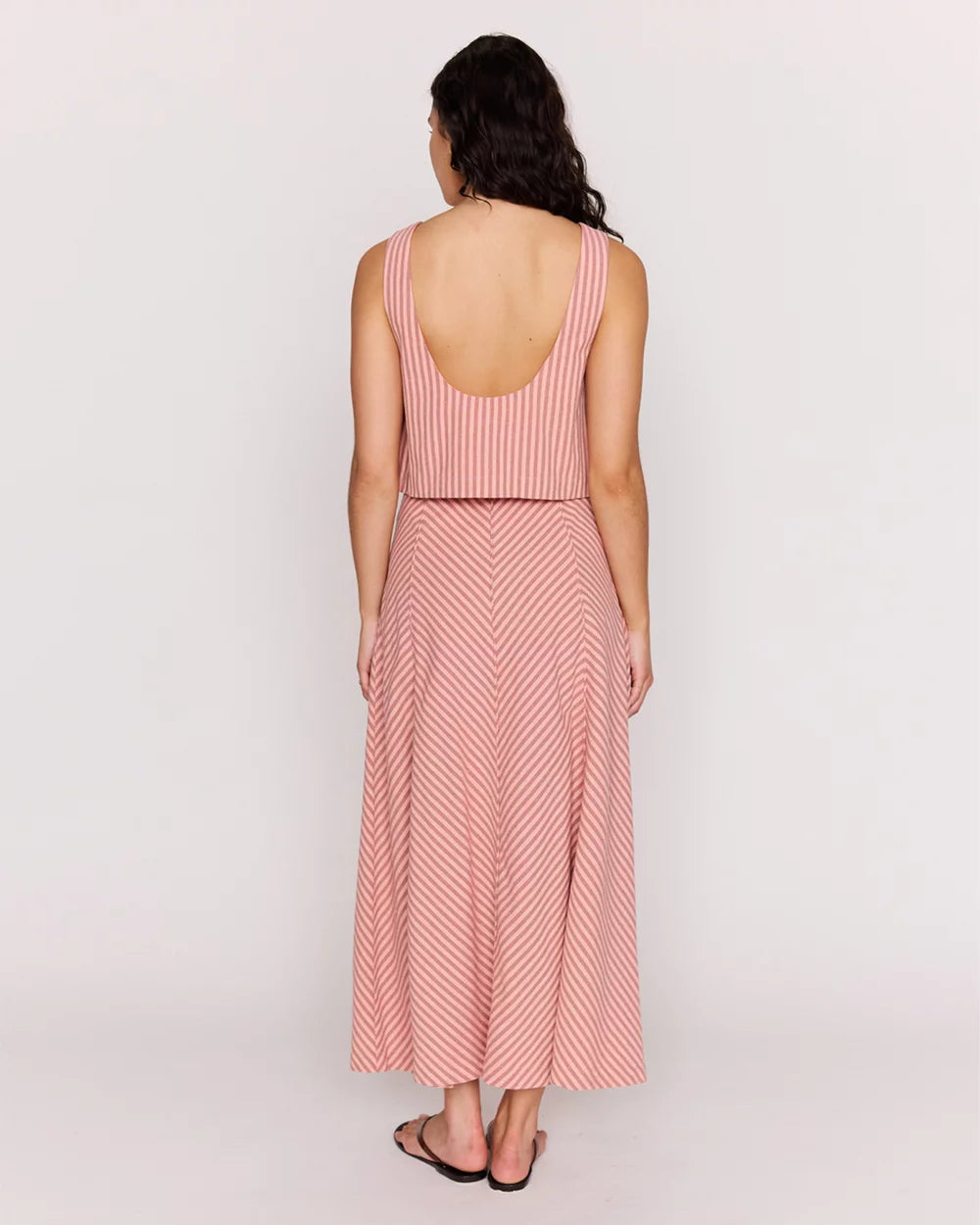 Woman wearing a pink striped dress on a white background