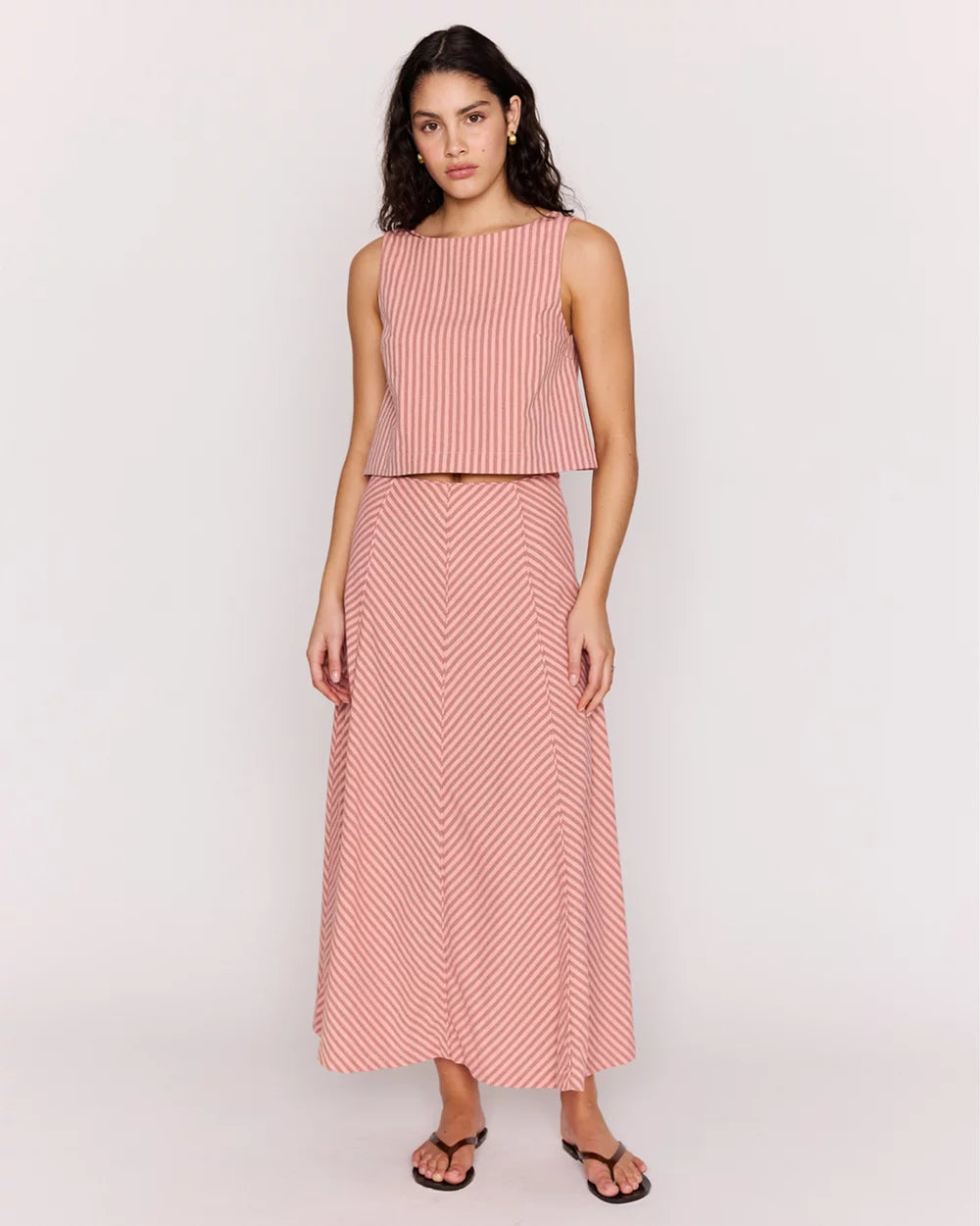 Woman wearing a pink and white striped outfit on a white background