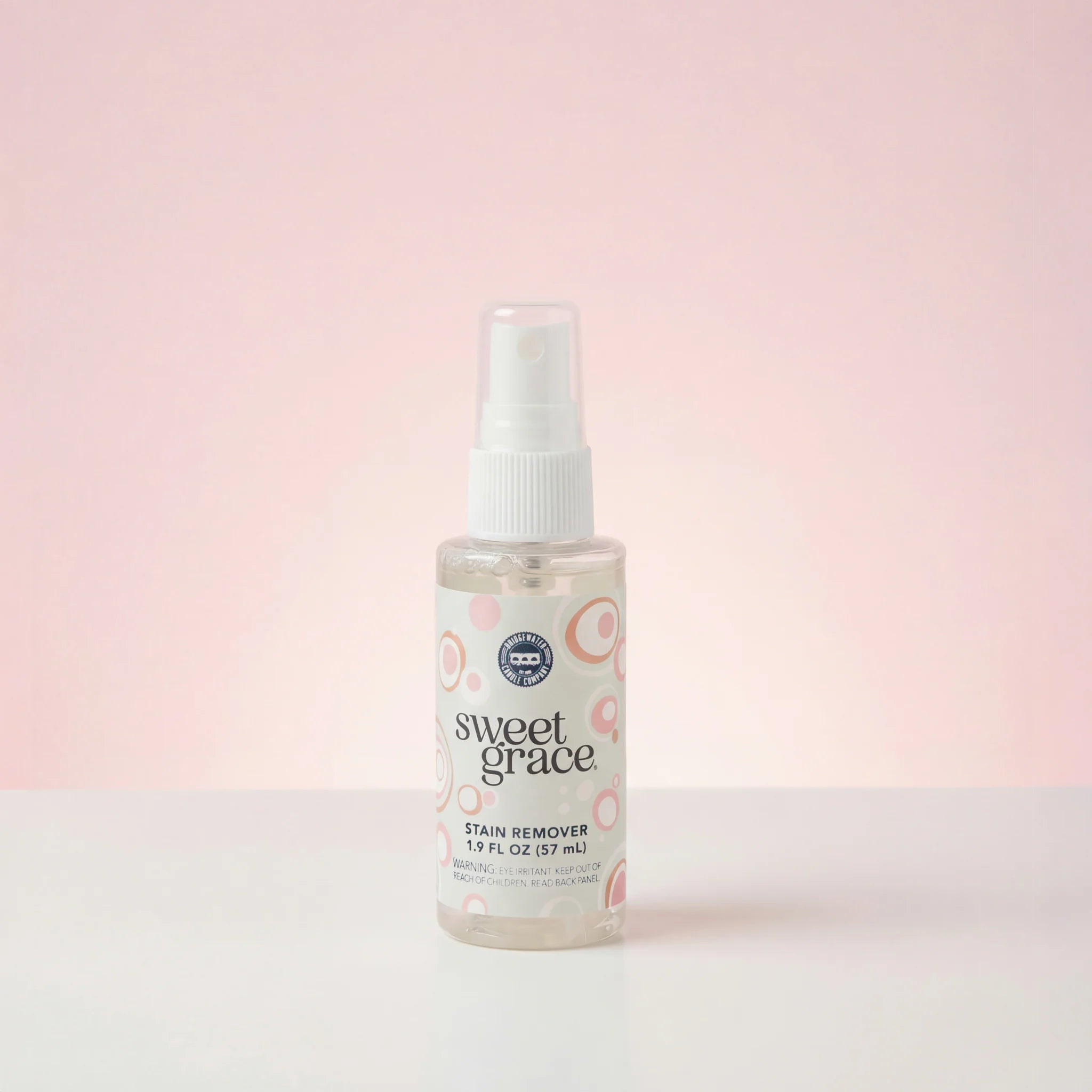 Bottle of sweet grace stain remover on a light pink background