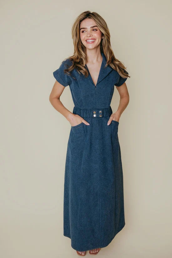 Woman wearing a blue dress against a beige background
