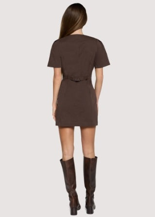 A woman shown from the back wearing a short-sleeve brown mini dress with a matching belt and dark brown knee-high boots, against a light gray studio background.