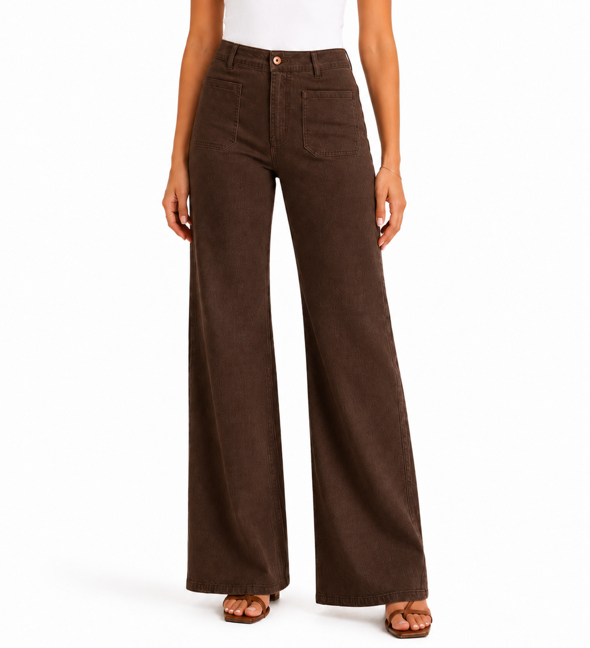 A model wearing a pair of dark brown wide-leg corduroy pants, styled with a white top and brown sandals, against a plain white background.